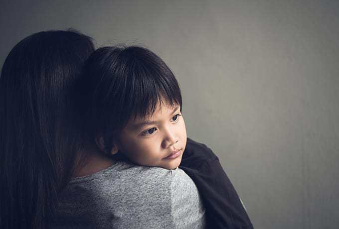 Supporting Children: Child being held by his mother after a suicide