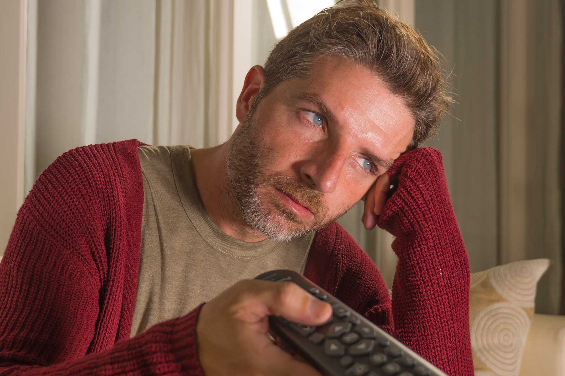 man anxious and stressed watching tv